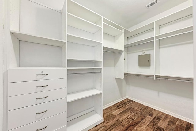 walk in closet with dark hardwood / wood-style floors