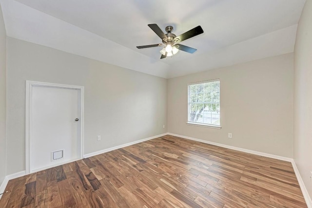 empty room featuring hardwood / wood-style flooring, vaulted ceiling, and ceiling fan