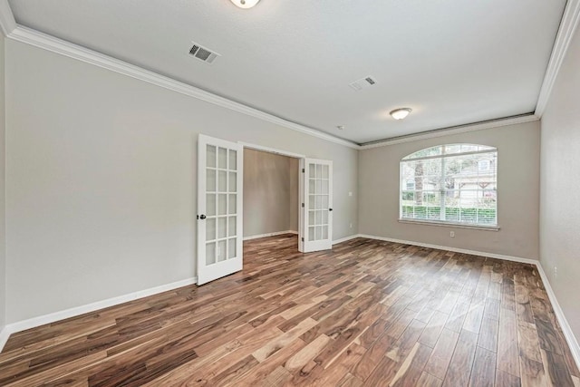 spare room with crown molding, french doors, and hardwood / wood-style flooring