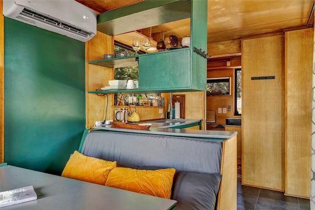 kitchen featuring dark tile patterned floors and a wall mounted AC