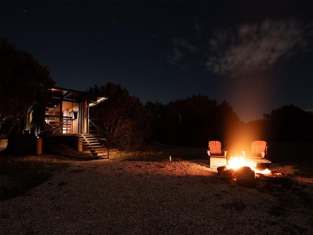 yard at twilight featuring an outdoor fire pit