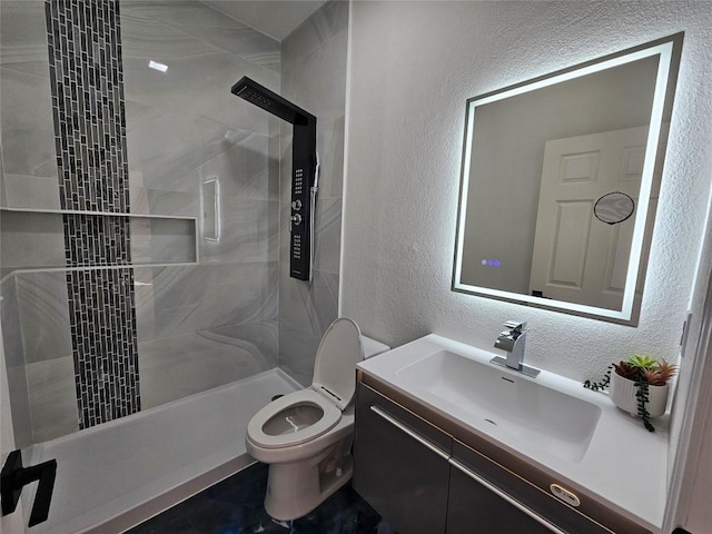 11806 Prairie Hen Ln, Austin, TX 78758 - bathroom featuring a textured wall, a tile shower, vanity, and toilet