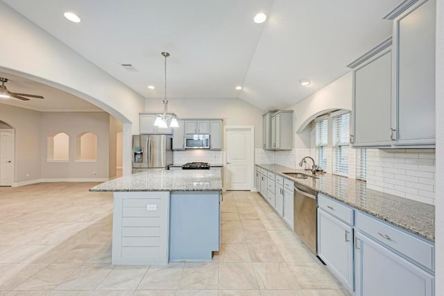 kitchen with a center island, sink, ceiling fan, decorative light fixtures, and stainless steel appliances