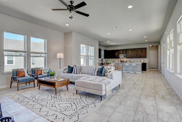 living room featuring ceiling fan and a wealth of natural light