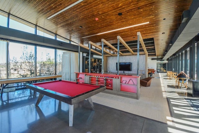 rec room with a towering ceiling, billiards, concrete flooring, and a pool