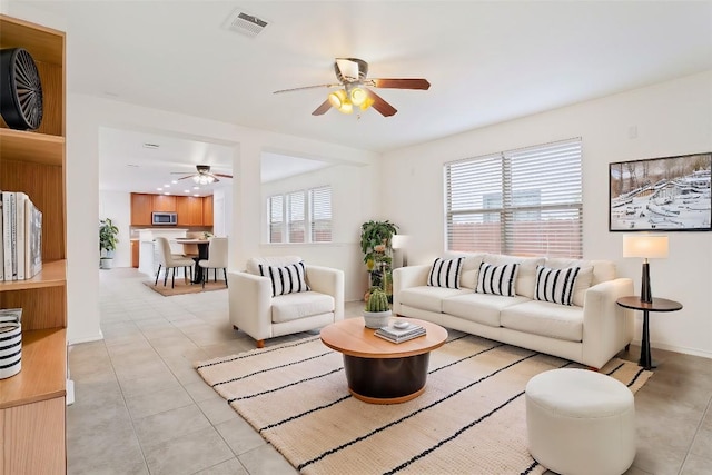 living room featuring a wealth of natural light, ceiling fan, and light tile patterned flooring