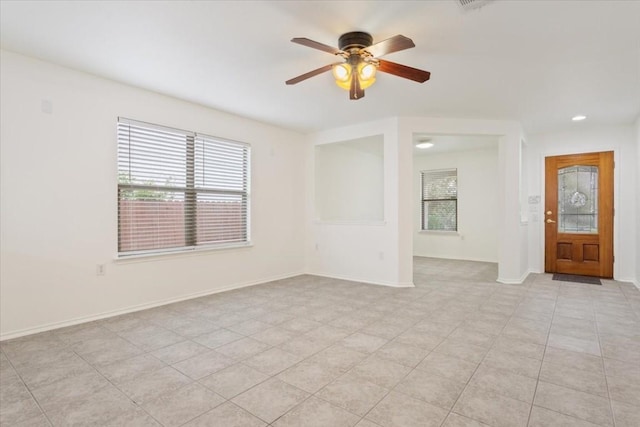 spare room with ceiling fan and light tile patterned floors