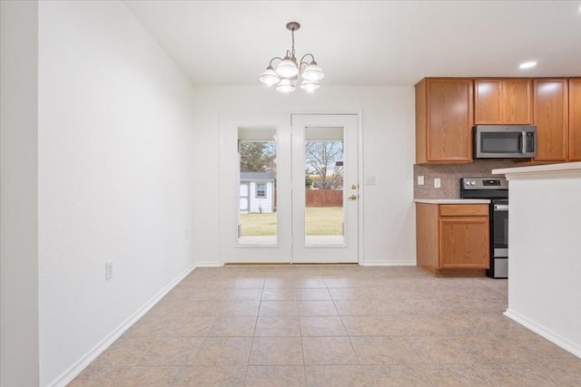 kitchen with hanging light fixtures, an inviting chandelier, backsplash, light tile patterned flooring, and appliances with stainless steel finishes