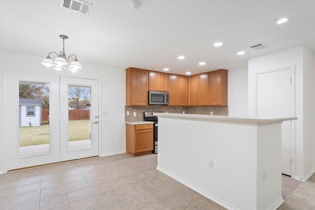 kitchen with tasteful backsplash, light tile patterned floors, decorative light fixtures, a notable chandelier, and range