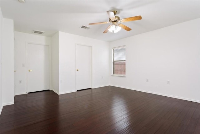 empty room with ceiling fan and dark hardwood / wood-style floors