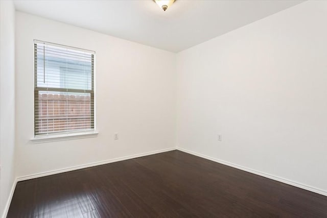 empty room with dark hardwood / wood-style flooring