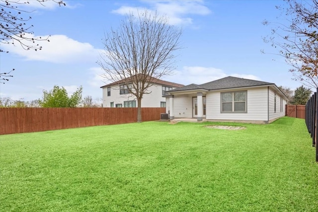 back of property featuring a lawn and central AC