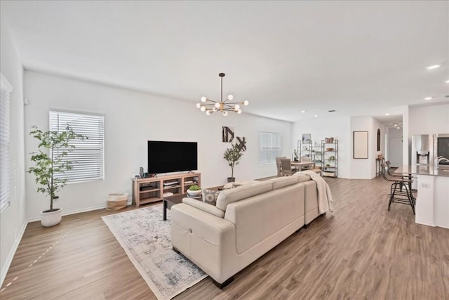 living room featuring light wood-type flooring and a notable chandelier