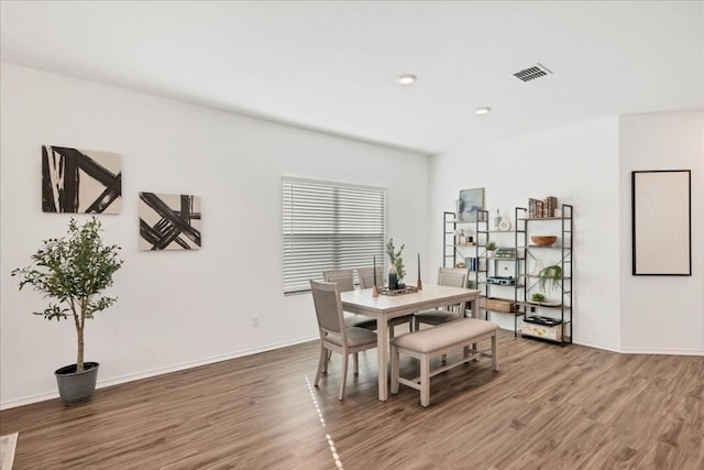 dining area featuring wood finished floors, visible vents, and baseboards