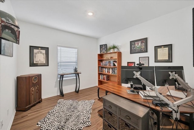 home office with light hardwood / wood-style flooring