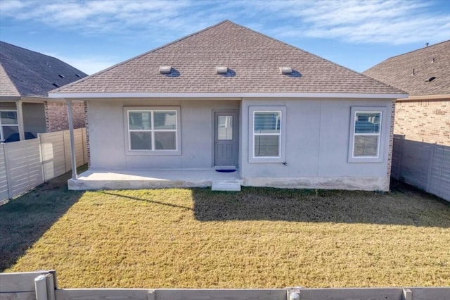 back of property featuring a shingled roof, a lawn, a fenced backyard, and stucco siding