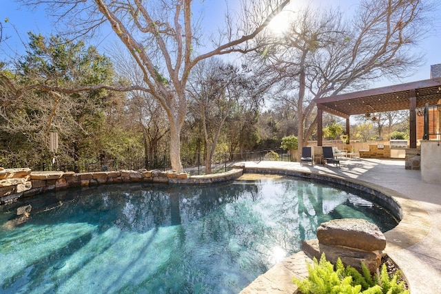 view of swimming pool featuring a patio and exterior kitchen