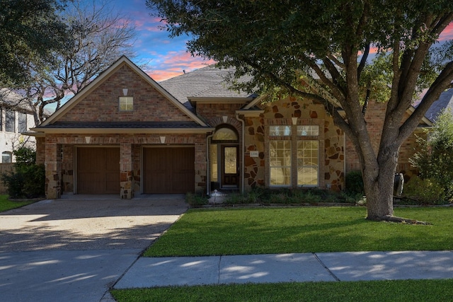 view of front of property featuring a garage and a lawn