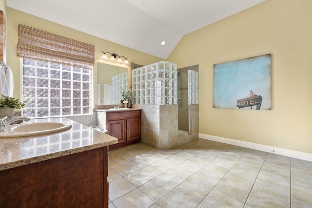 bathroom featuring tile patterned flooring, a tile shower, vanity, and lofted ceiling