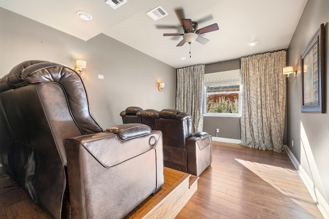 home theater room with ceiling fan and wood-type flooring