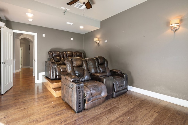 home theater room with hardwood / wood-style flooring and ceiling fan