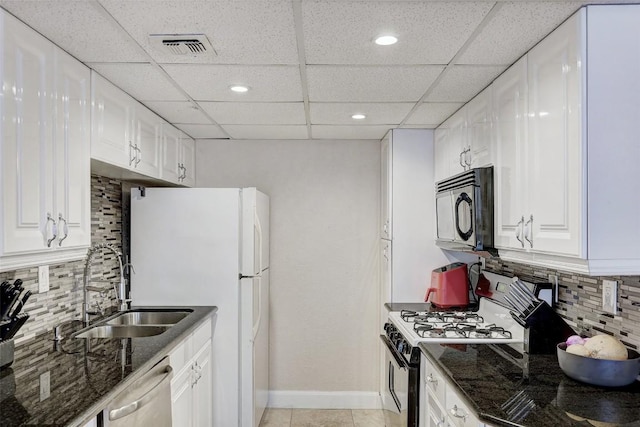 kitchen featuring backsplash, white cabinetry, white appliances, and sink