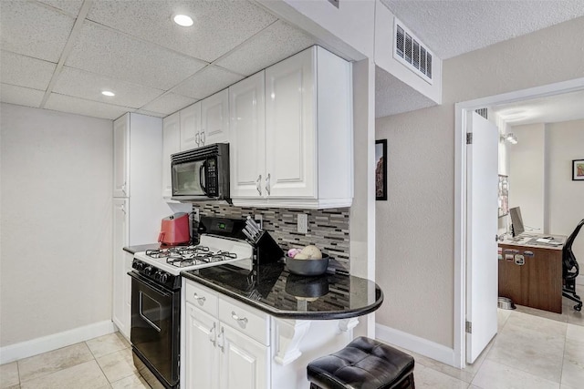 kitchen featuring black appliances, light tile patterned flooring, white cabinets, and backsplash