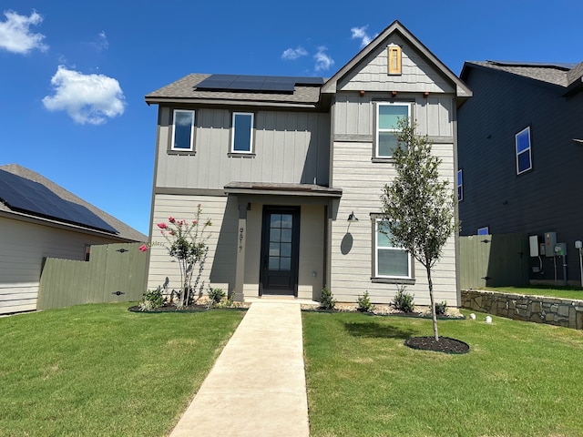 view of front of property featuring a front yard and solar panels