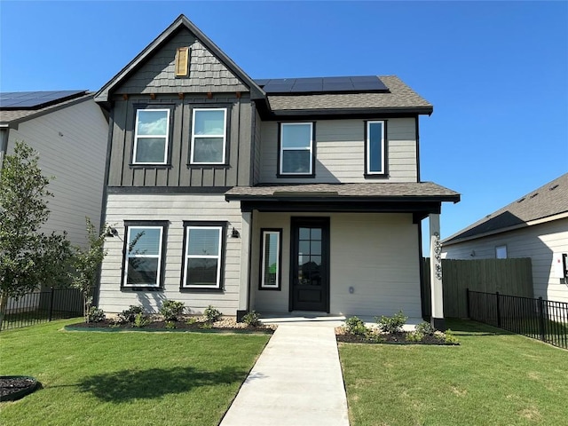 view of front of home with a front yard and solar panels