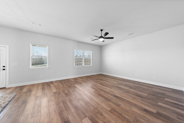 unfurnished room featuring dark hardwood / wood-style floors, a wealth of natural light, and ceiling fan