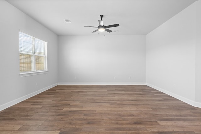 empty room with ceiling fan and dark hardwood / wood-style flooring