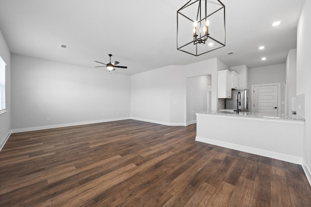 unfurnished living room featuring dark hardwood / wood-style flooring and ceiling fan