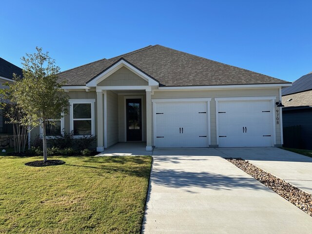 view of front of house featuring a garage and a front lawn