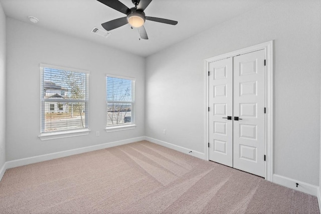 carpeted spare room with ceiling fan