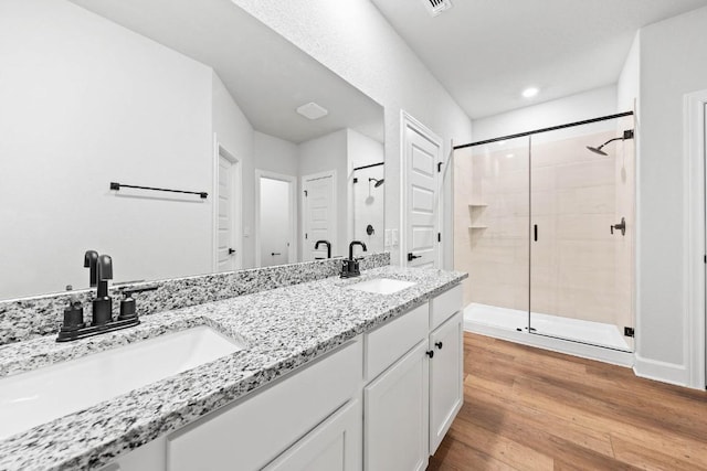 bathroom featuring vanity, a shower with door, and hardwood / wood-style floors