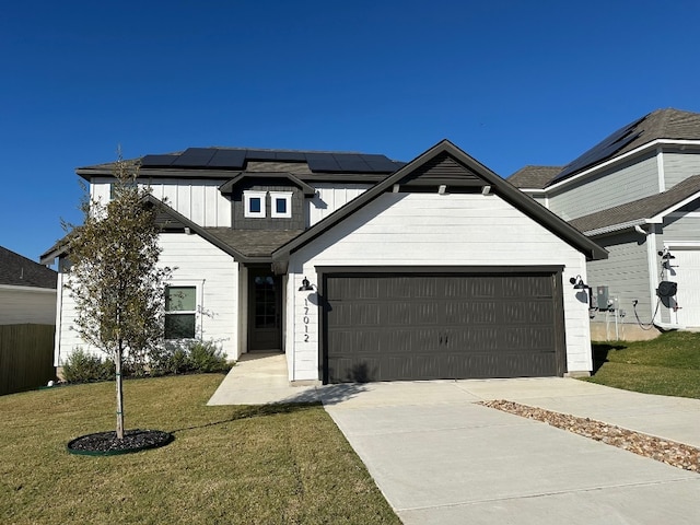 view of front facade with solar panels, a garage, and a front lawn