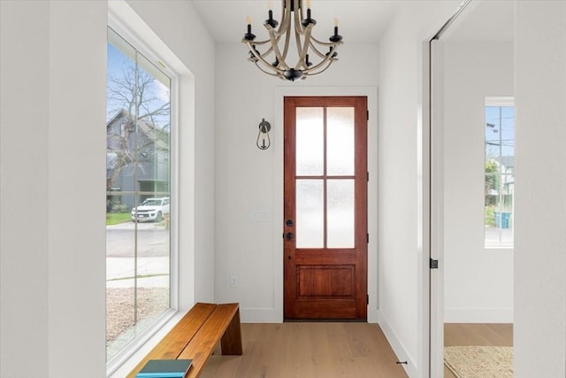 doorway to outside featuring light hardwood / wood-style floors and a notable chandelier