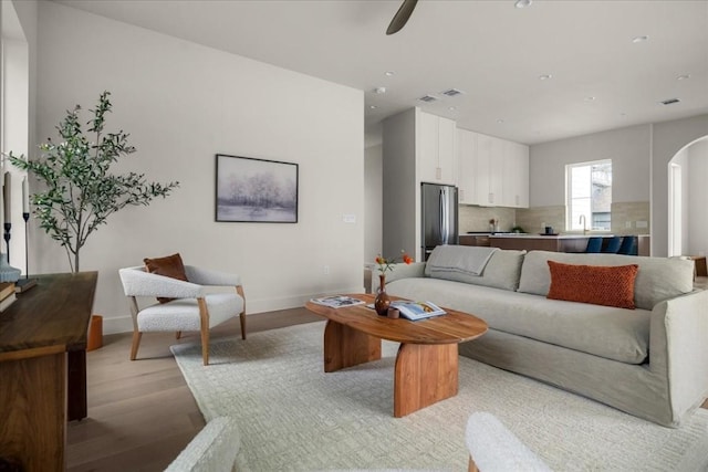 living room featuring ceiling fan and light wood-type flooring