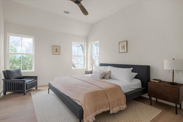 bedroom featuring light hardwood / wood-style flooring, vaulted ceiling, and ceiling fan