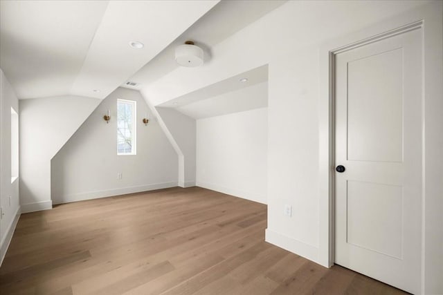 bonus room with hardwood / wood-style flooring and lofted ceiling