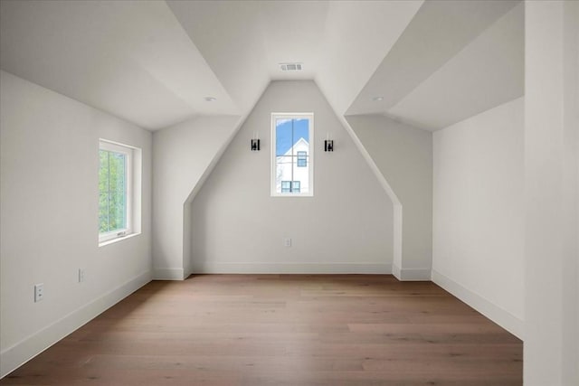 bonus room with light hardwood / wood-style flooring and lofted ceiling