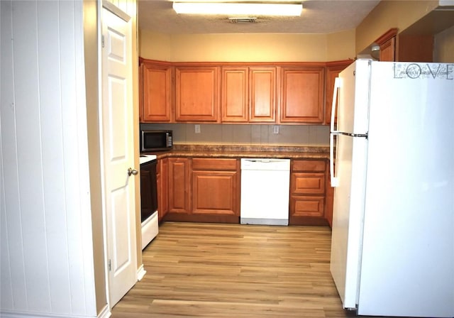 kitchen with white appliances and light wood-type flooring