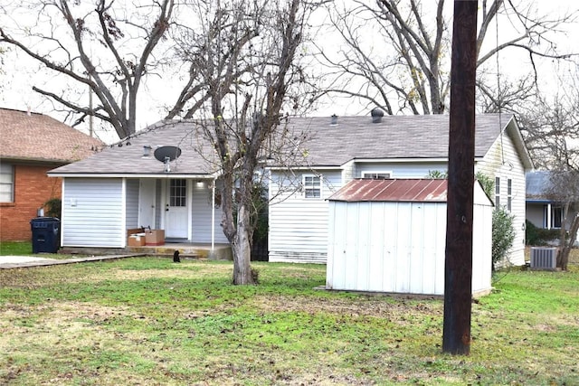 view of front of house featuring central AC unit, a shed, and a front yard