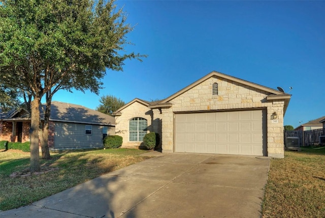 single story home featuring concrete driveway, an attached garage, fence, and a front yard