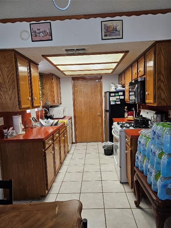 kitchen with white appliances and light tile patterned floors