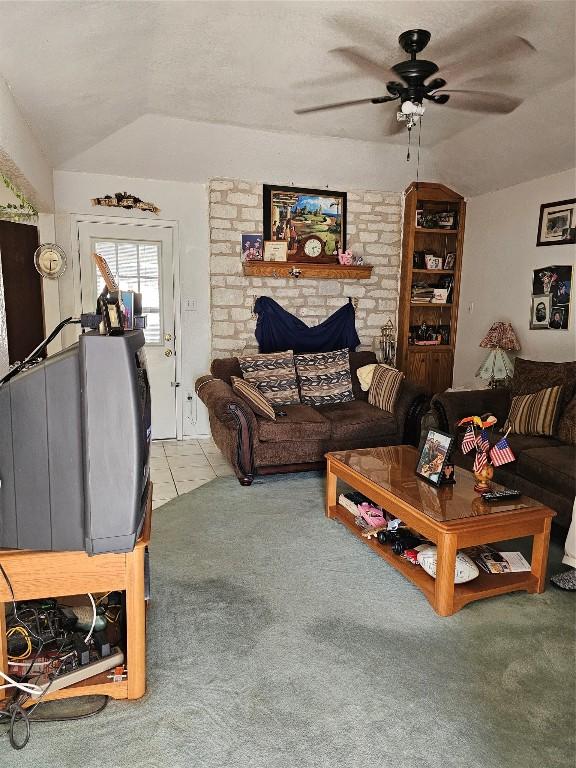 living room featuring vaulted ceiling, ceiling fan, and light tile patterned flooring