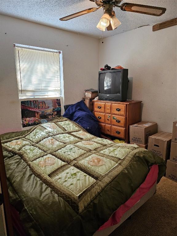 bedroom with a textured ceiling and ceiling fan