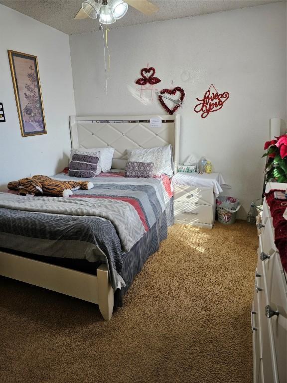 carpeted bedroom with a textured ceiling and ceiling fan