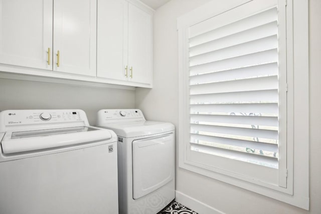 laundry room featuring washer and clothes dryer and cabinets