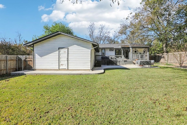 back of property with a yard and a patio area